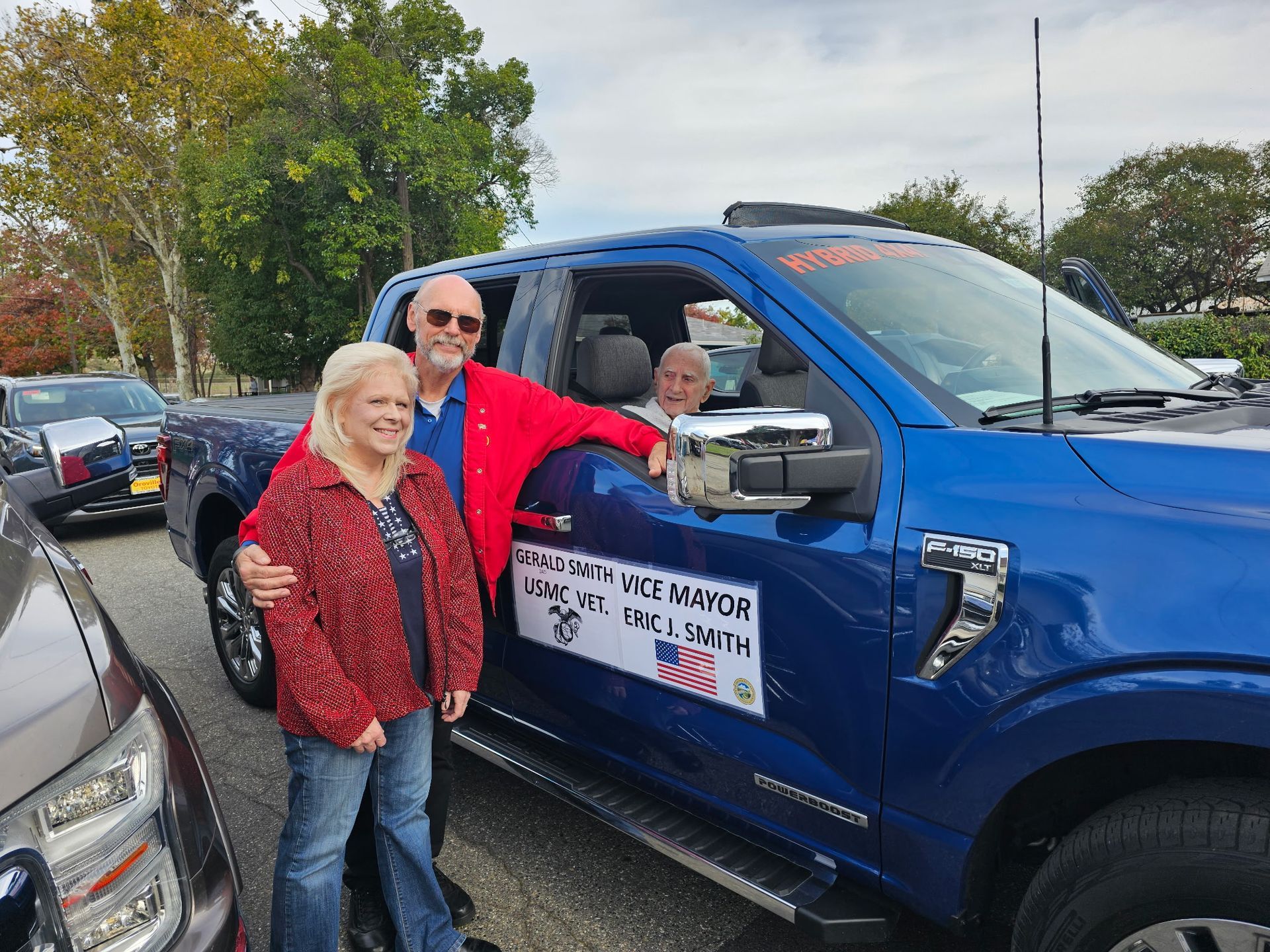 Eric Smith, Oroville Chamber President/CEO and Vice Mayor, stands with his wife Tammy Smith beside a blue F-150 truck while Eric’s father, U.S. Marine Corps Veteran Gerald Smith, sits in the passenger seat before the Veterans Day Parade.