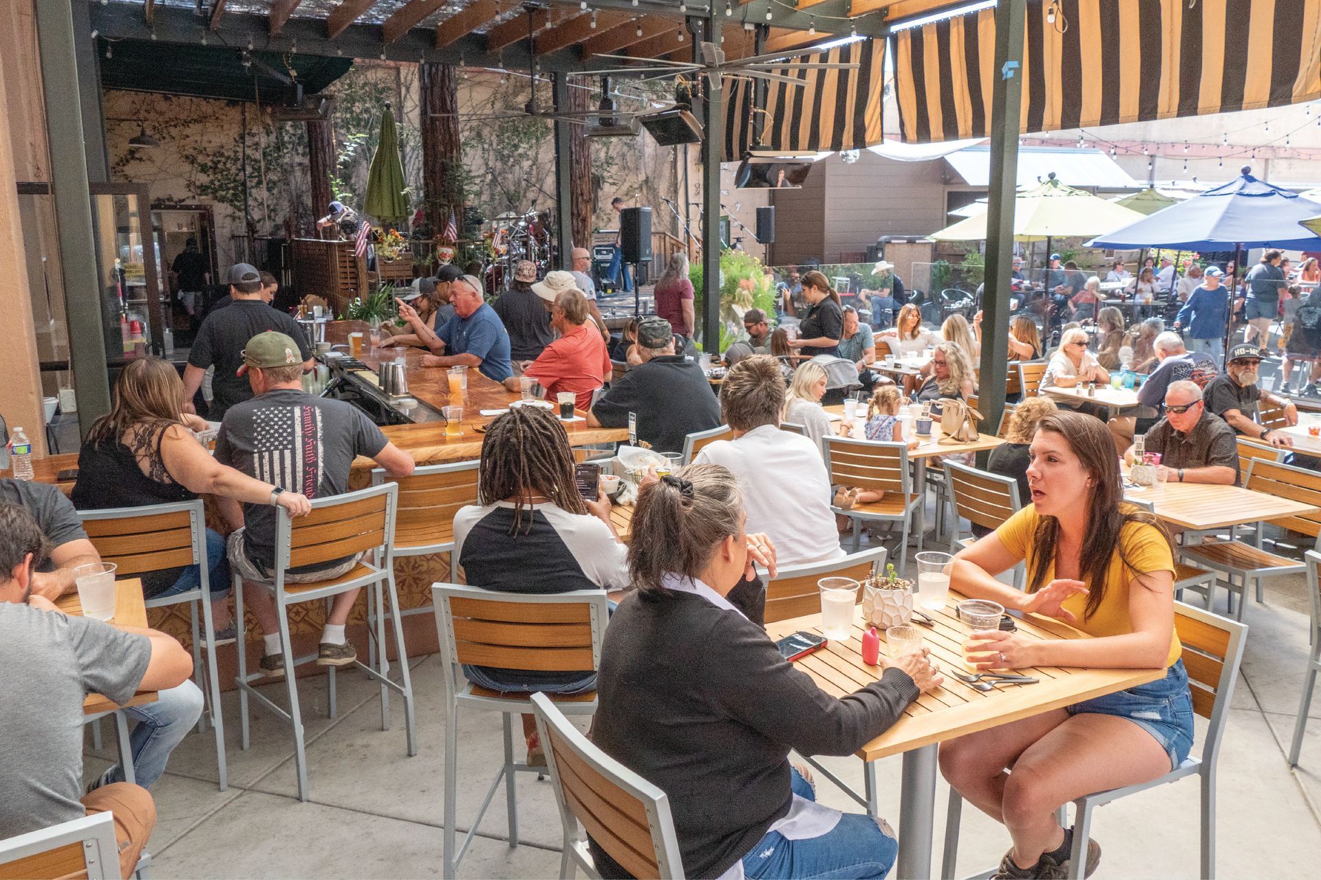 Crowds enjoy food, drinks, and live music at an outdoor dining area during the Salmon Festival in Downtown Oroville.