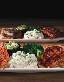 Two plates of food are sitting on a wooden table.