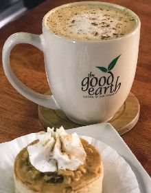 A cup of coffee and a piece of cake on a table.