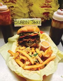 A hamburger and french fries with a sign that says blazin jake