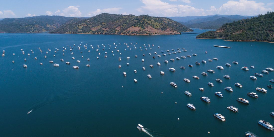 An aerial view of a large body of water filled with boats.