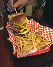 A hamburger and french fries in a basket on a table.