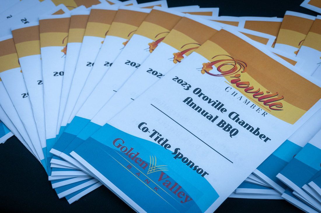 A stack of pamphlets for the oroville chamber annual bbq