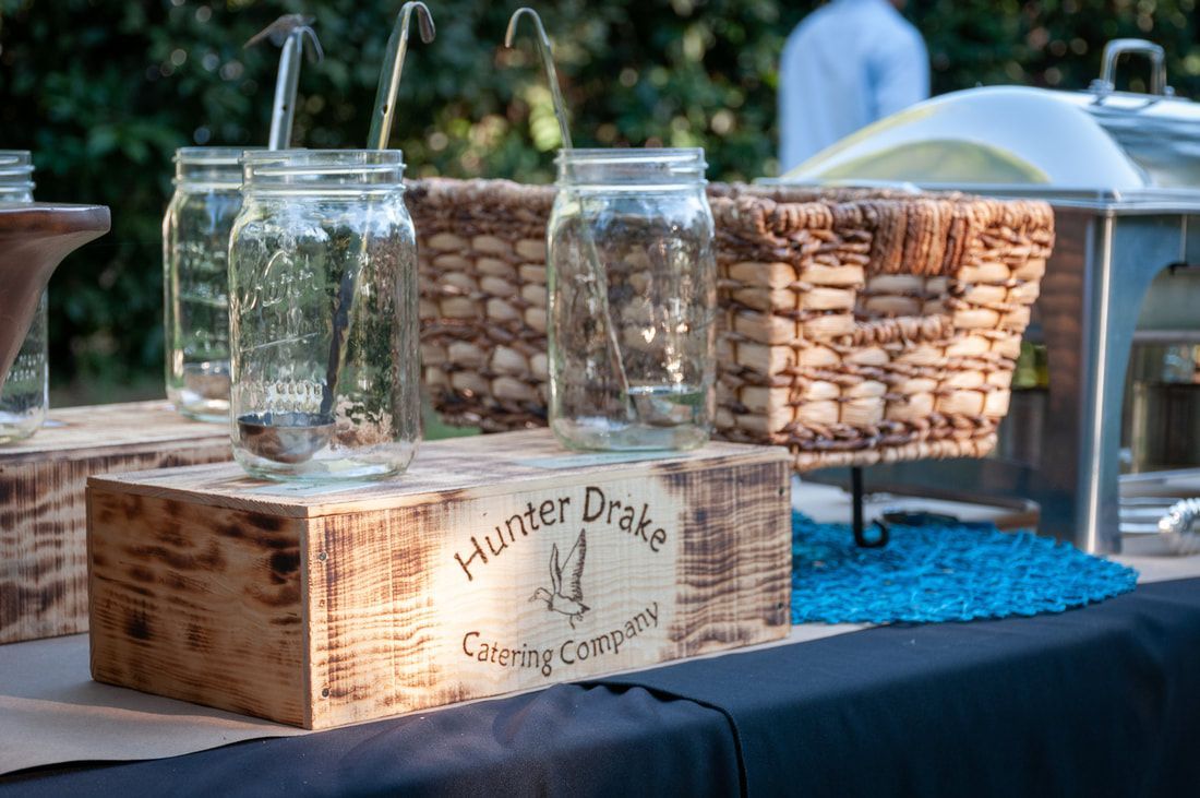 A wooden box with mason jars and baskets on it is on a table.