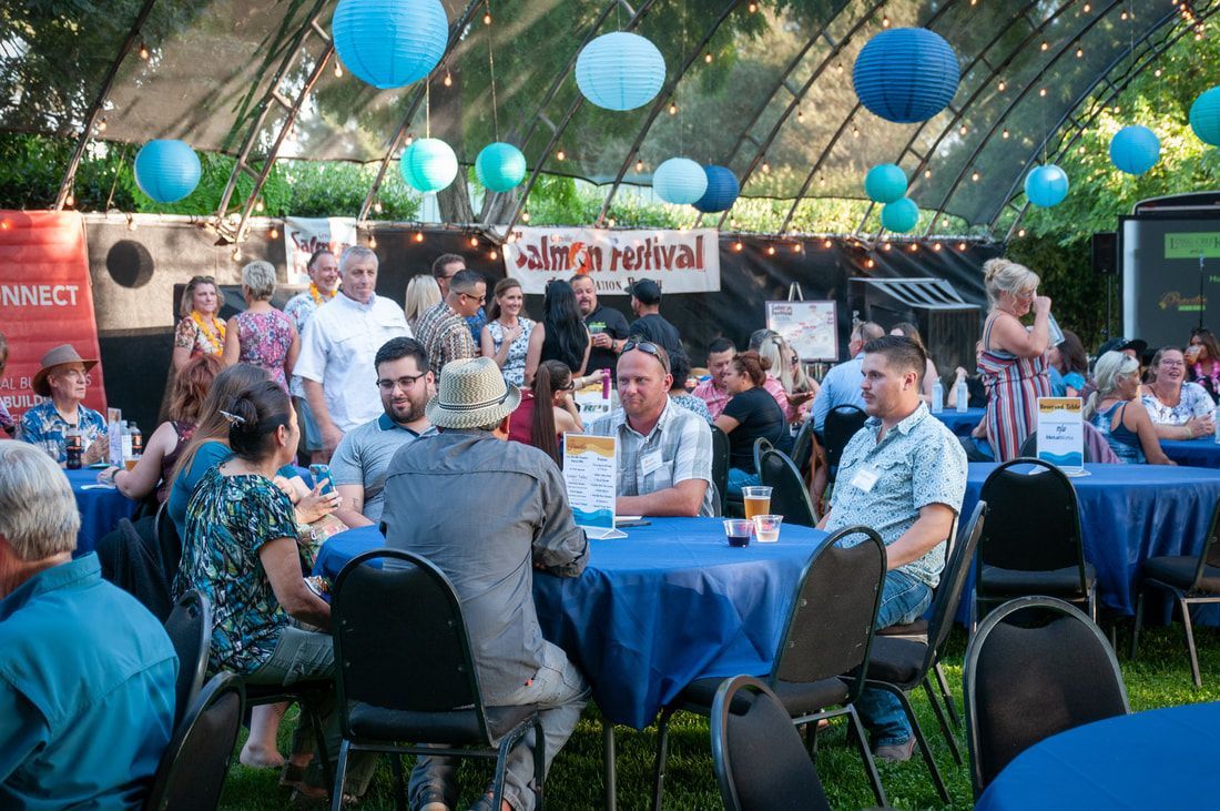 A group of people are sitting at tables at a party.