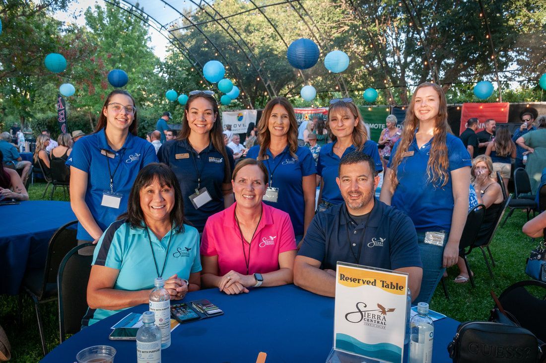 A group of people are posing for a picture at a table.