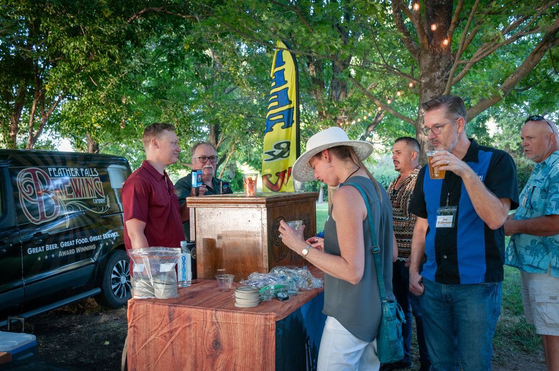 A group of people are standing around a wooden table.