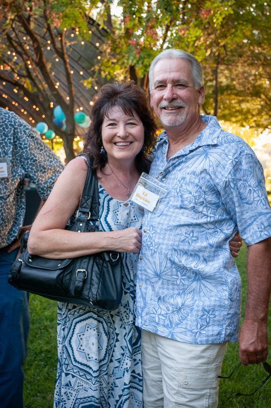 A man and a woman are posing for a picture in a park.