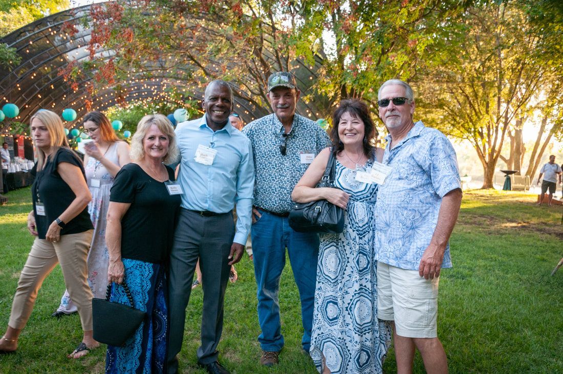 A group of people are posing for a picture in a park.