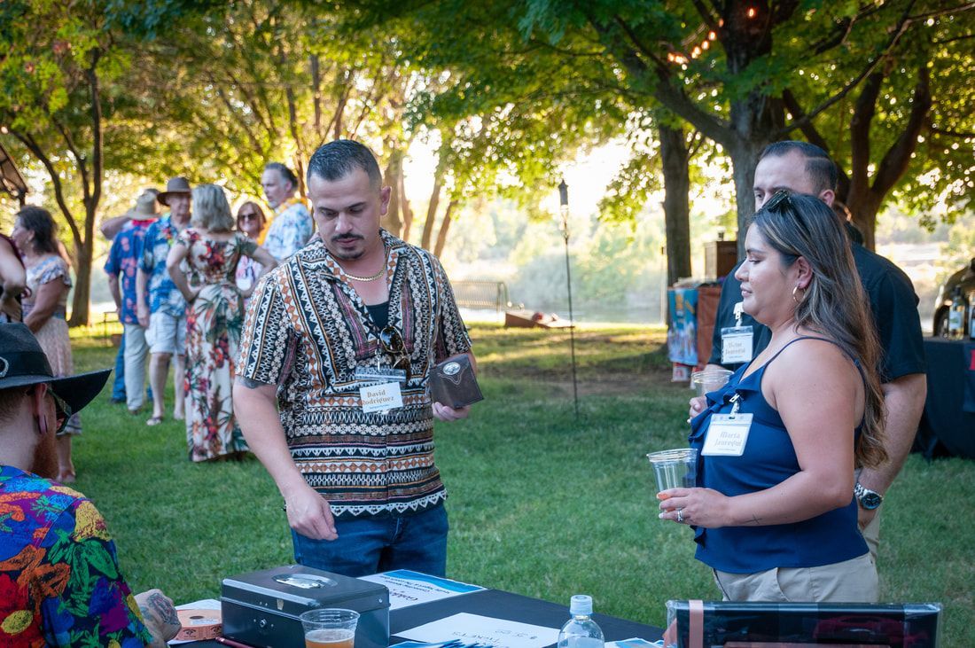 A group of people are standing around a table in a park.