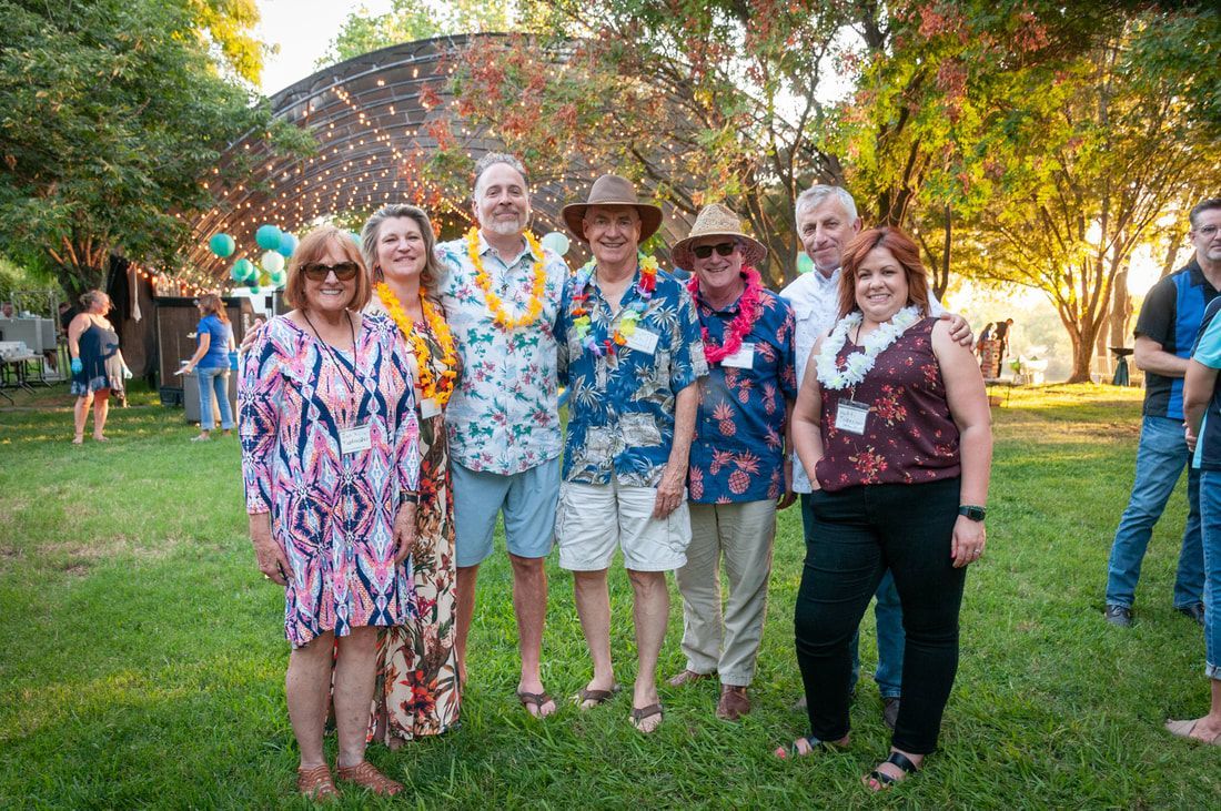 A group of people are posing for a picture in a park.