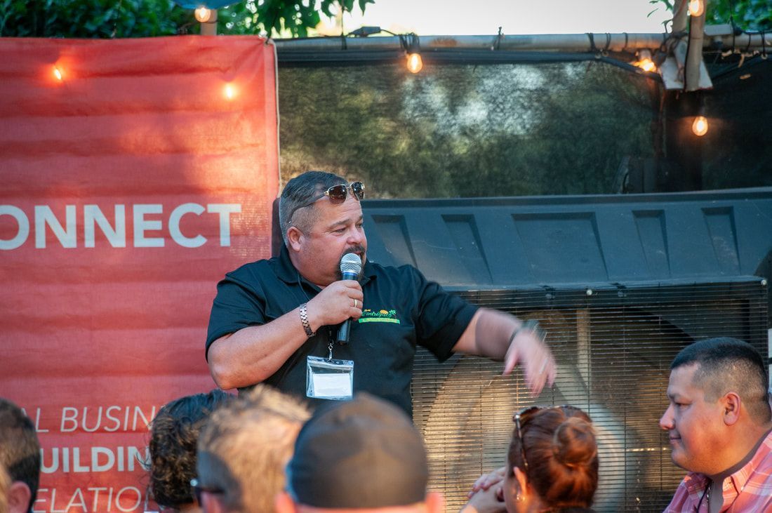 A man is speaking into a microphone in front of a group of people.