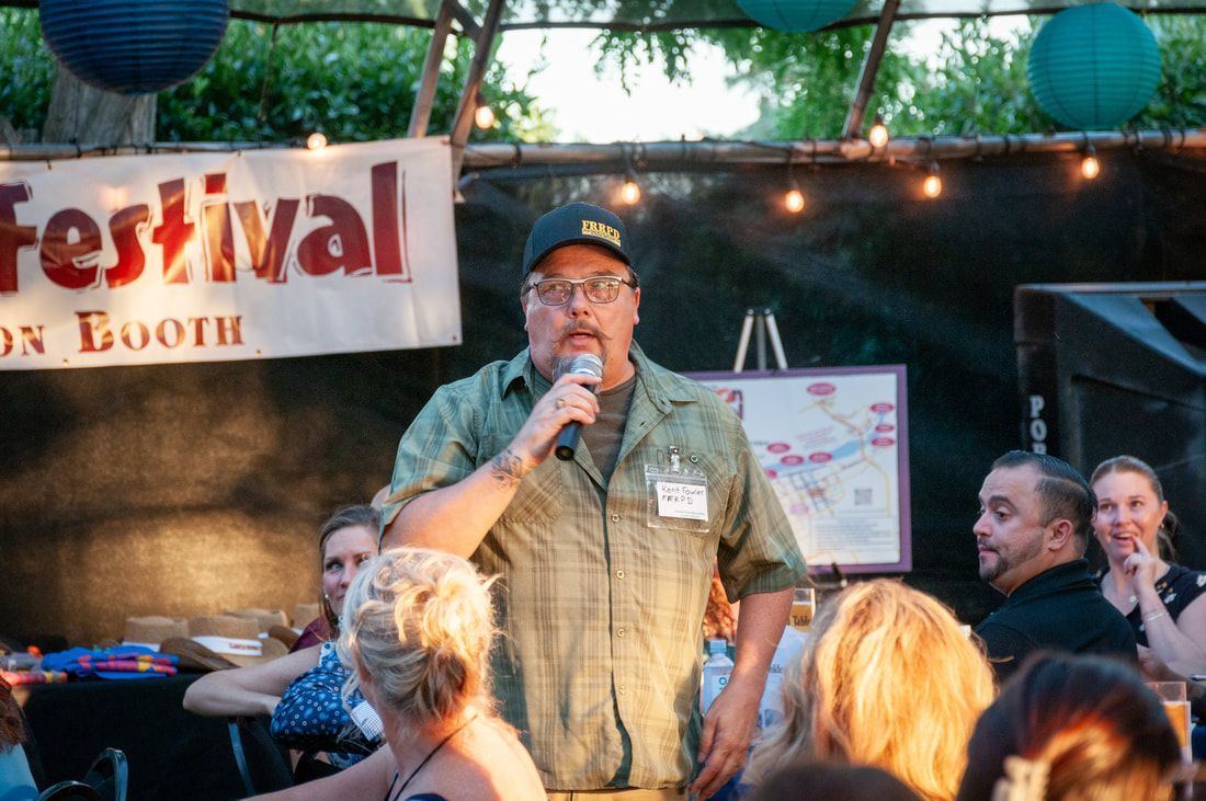 A man is speaking into a microphone at a festival