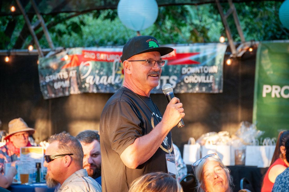 A man is holding a microphone in front of a crowd of people.