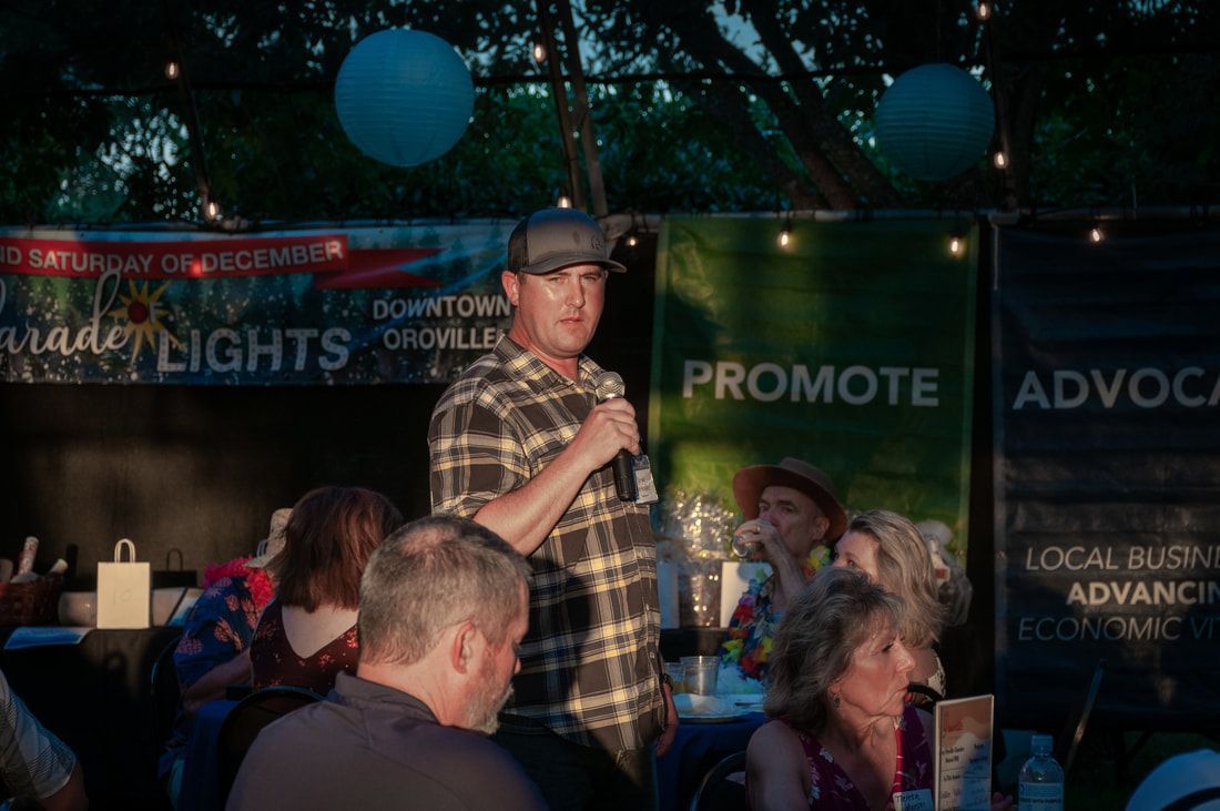 A man is standing in front of a crowd holding a microphone.