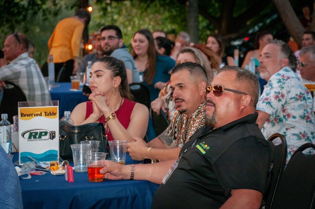 A group of people are sitting at tables at a party.