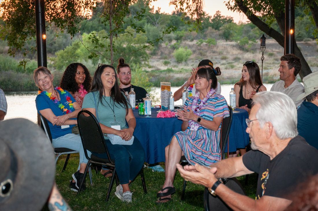 A group of people are sitting around a table in a circle.
