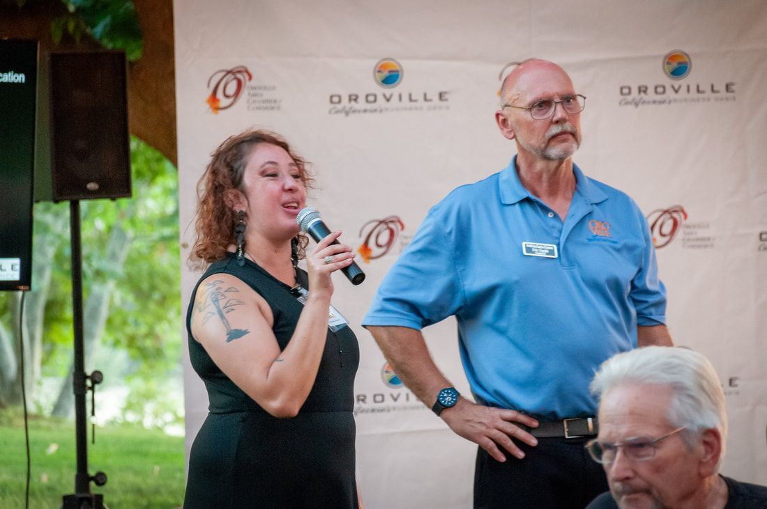 A woman is holding a microphone while standing next to a man.