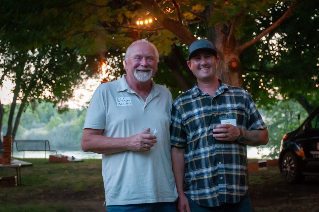 Two men are standing next to each other in a park.
