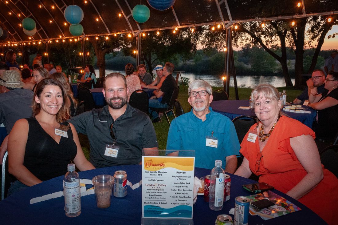 A group of people are sitting at a table under a tent.