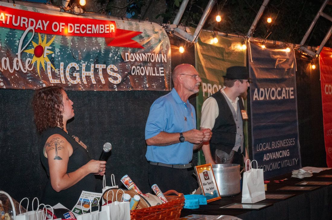 A group of people are standing in front of a sign that says saturday of december