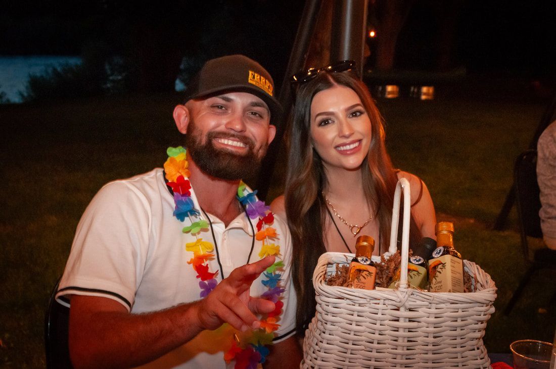 A man and a woman are posing for a picture while holding a basket of drinks.