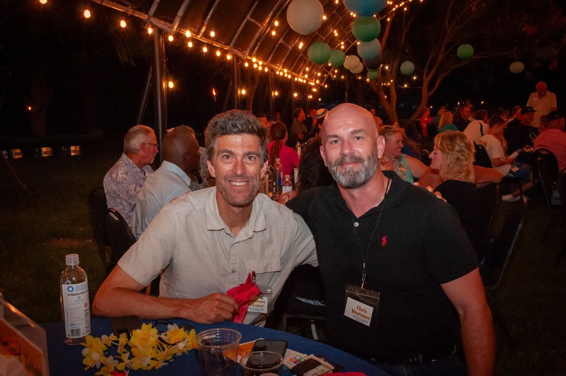 Two men are posing for a picture at a party.