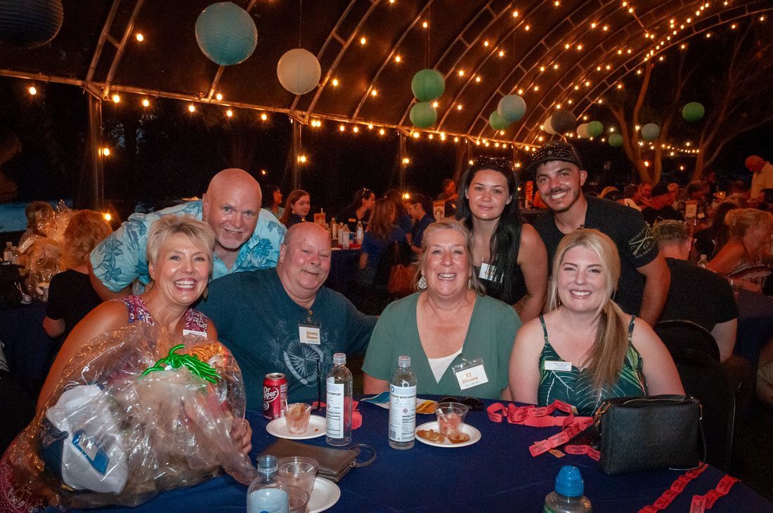A group of people are posing for a picture at a table.