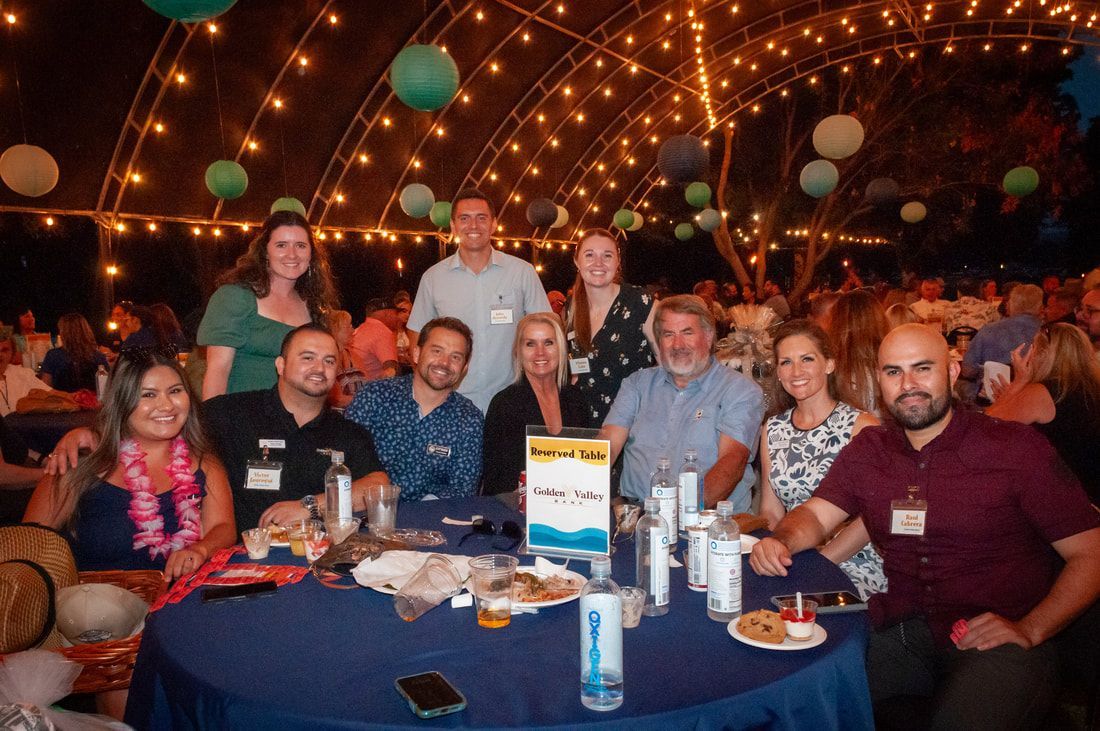 A group of people are sitting around a table at a party.