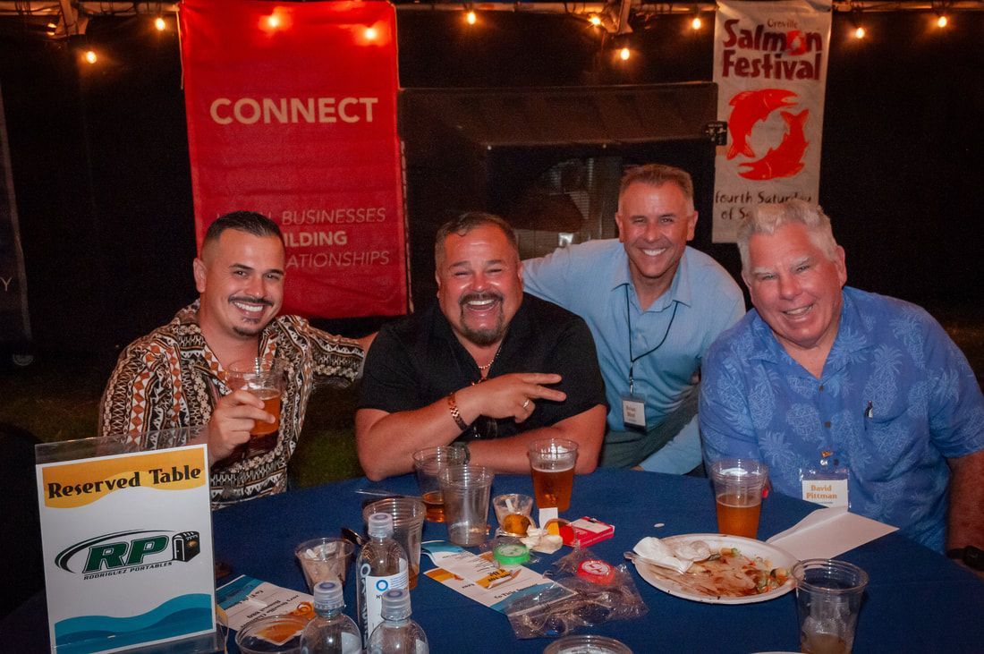 Four men are sitting at a table with a sign that says connect