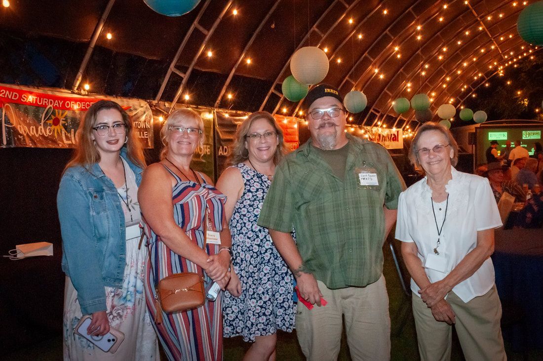 A group of people are posing for a picture in a tent.