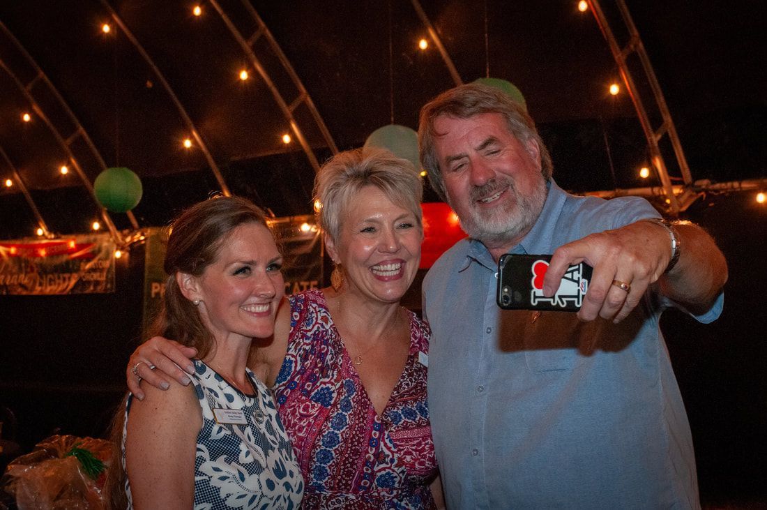 A man is taking a selfie with two women at a party.
