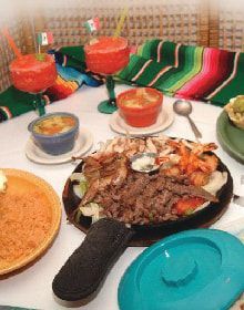 A table topped with plates of food and drinks.