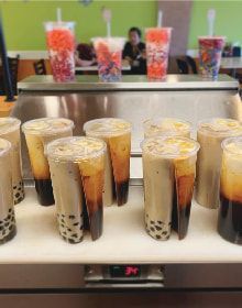 A display of bubble tea cups on a counter in a restaurant.