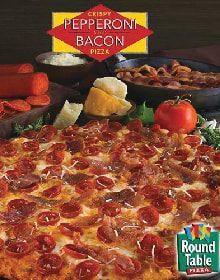 A pepperoni bacon pizza is sitting on top of a wooden table.