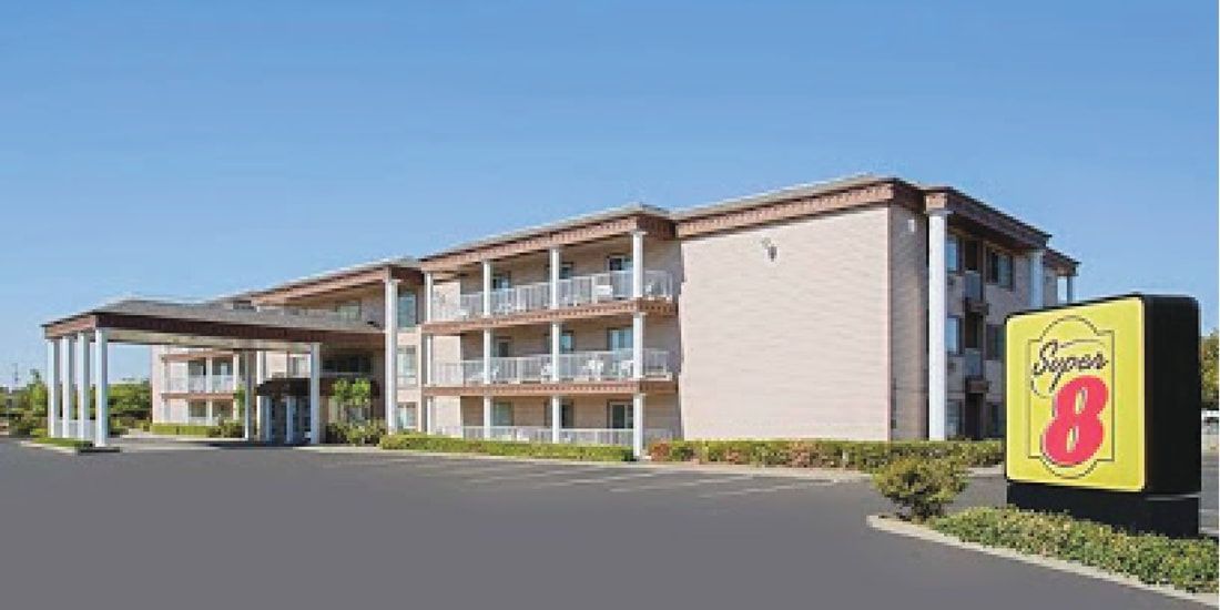 A large hotel with a sign that says super 8 on it.