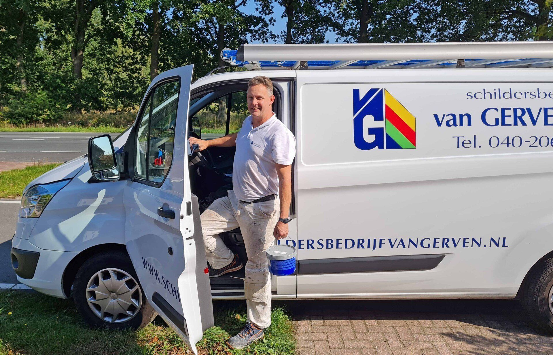 Man standing by a white van with the company logo