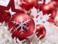 A close up of a red christmas ornament with a snowflake on it.