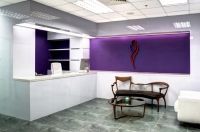 A waiting room with a purple wall and a table and chairs.