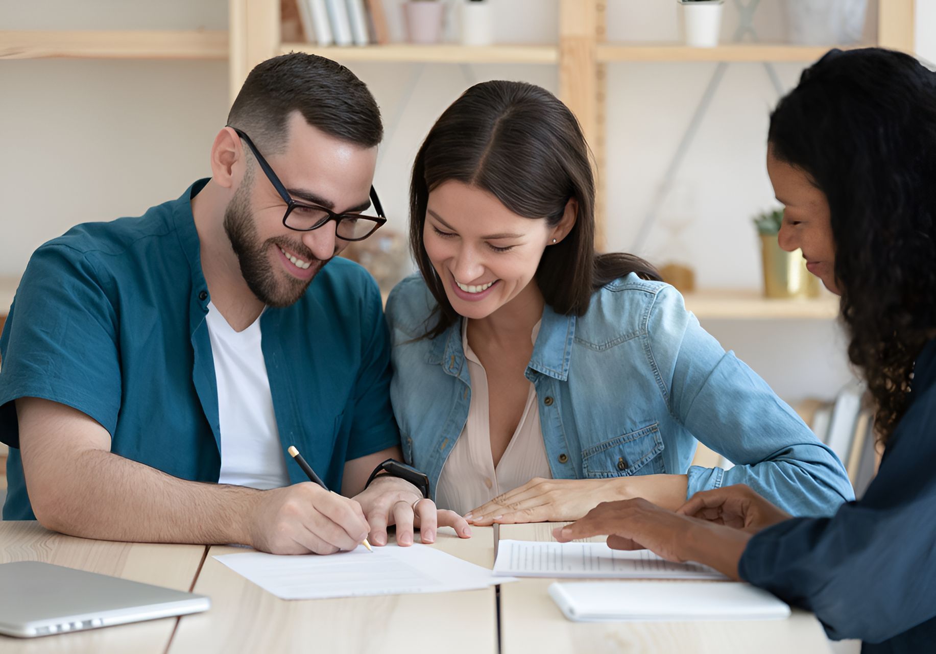A Man and a Woman Are Sitting at a Table Signing a Document — MoneySmith Group In Kingscliff, NSW