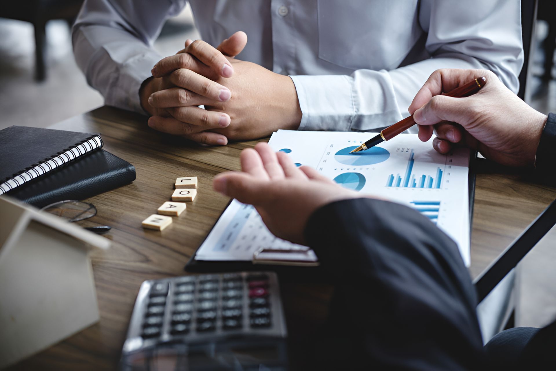 Two Men Are Sitting at a Table Looking at a Graph — MoneySmith Group In Kingscliff, NSW