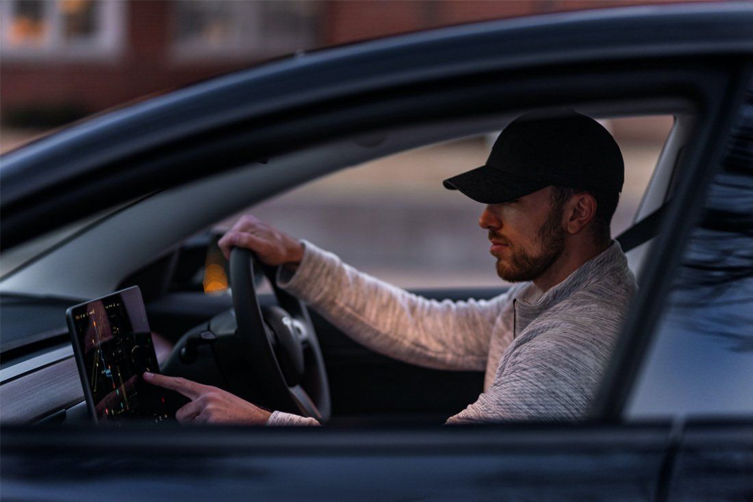 Man is Driving a Car and Using a Tablet — MoneySmith Group In Kingscliff, NSW