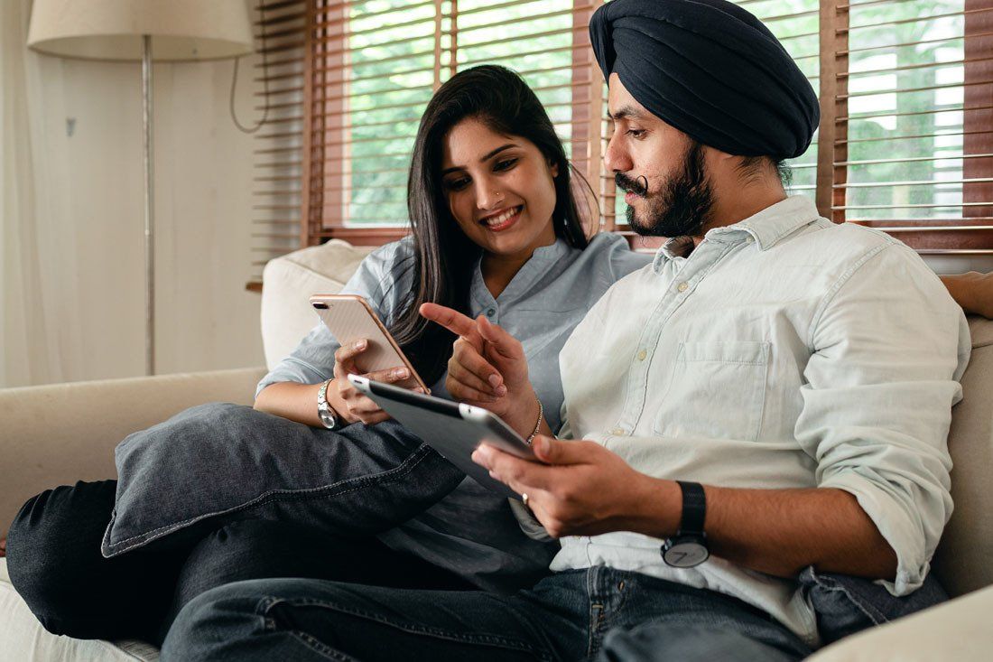 Man and a Woman Are Sitting on a Couch — MoneySmith Group In Kingscliff, NSW