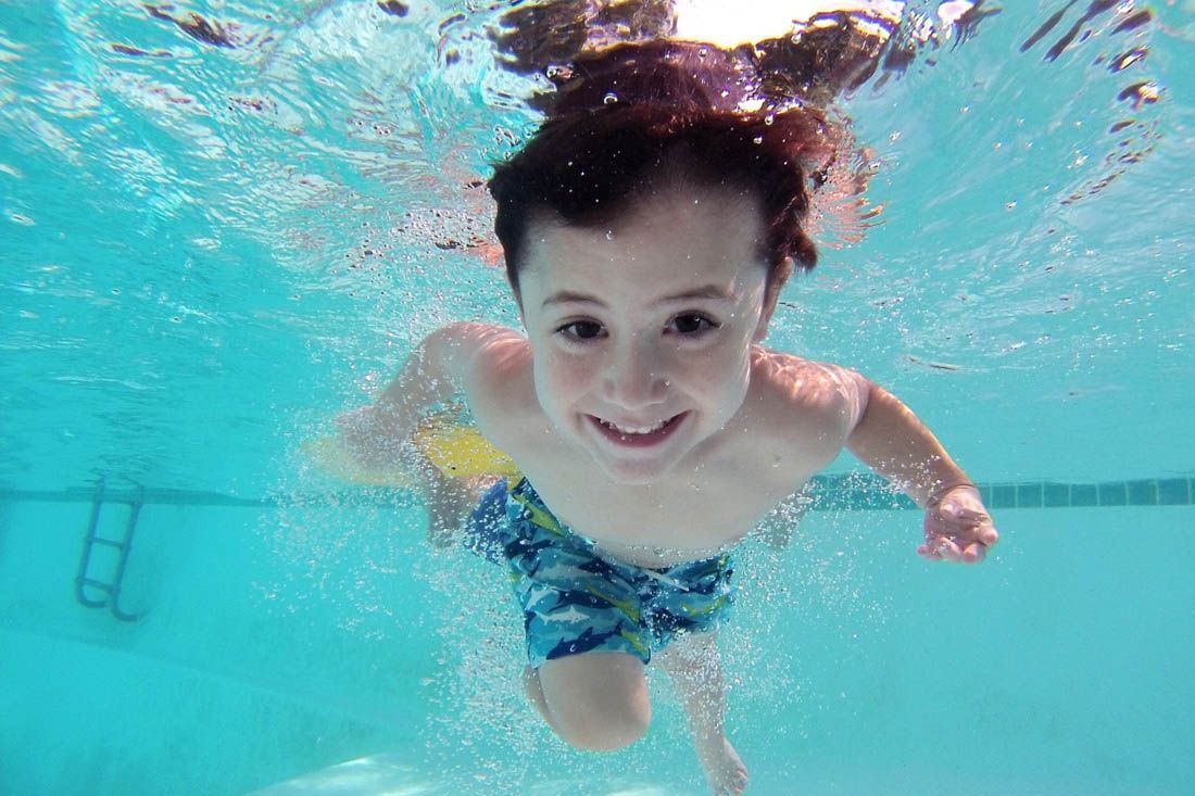 A Young Boy is Swimming Underwater in a Swimming Pool — MoneySmith Group In Kingscliff, NSW