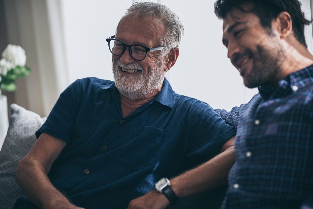 Two Men Are Sitting on a Couch Talking to Each Other — MoneySmith Group In Kingscliff, NSW