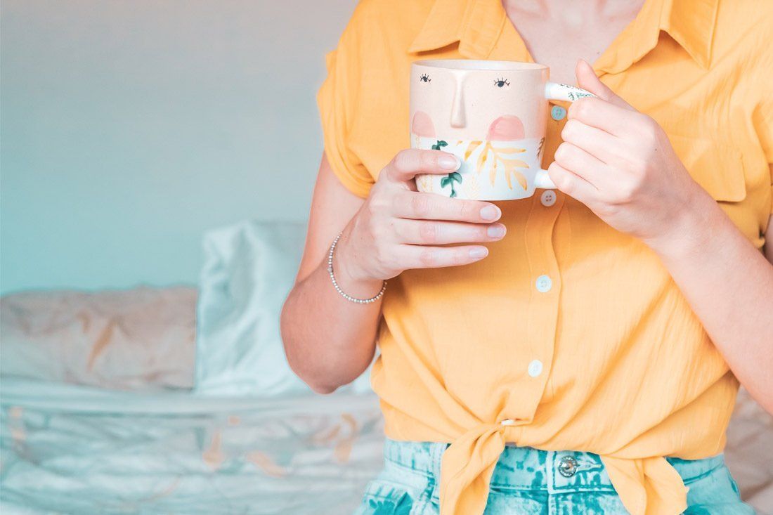 Woman in a Yellow Shirt is Holding a Mug — MoneySmith Group In Kingscliff, NSW