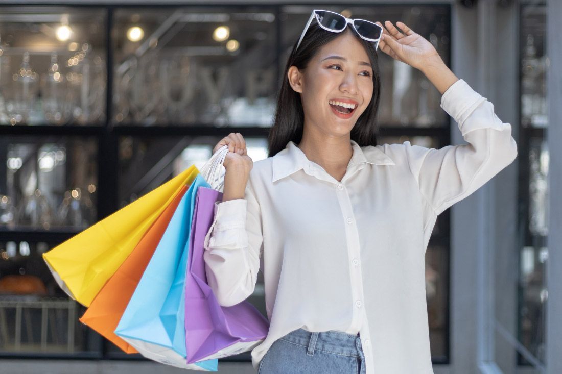 A Woman is Holding a Bunch of Shopping Bags — MoneySmith Group In Kingscliff, NSW