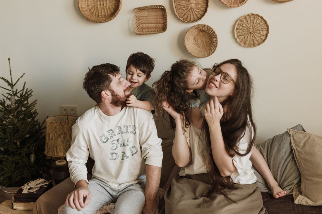 A Family is Sitting on a Couch in a Living Room — MoneySmith Group In Kingscliff, NSW