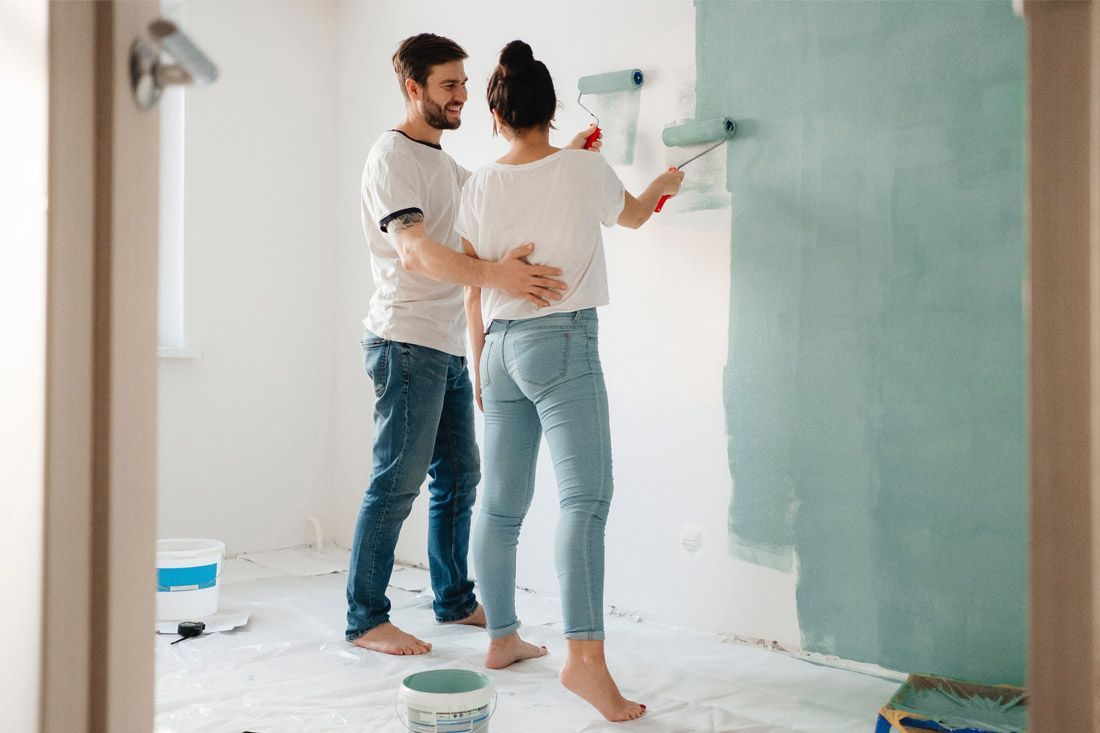 A Man and a Woman Are Painting a Wall Together — MoneySmith Group In Kingscliff, NSW